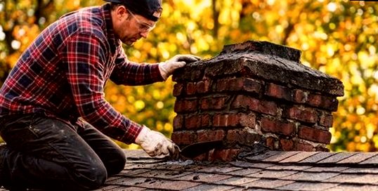 Mason resetting brick courses on a foothill chimney stack